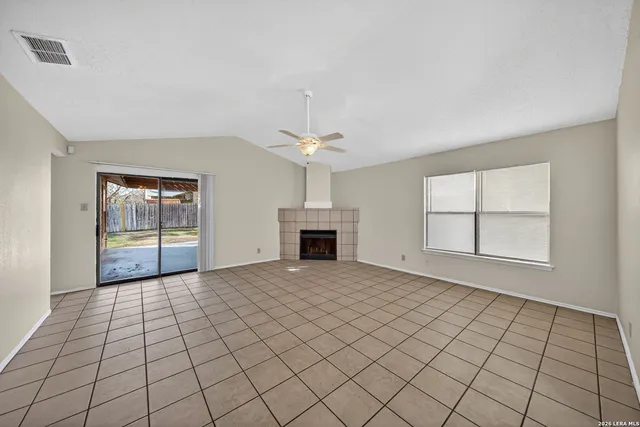 a view of an empty room with a fireplace and a window