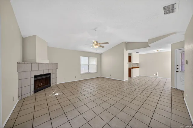 a view of an empty room with window and fire place