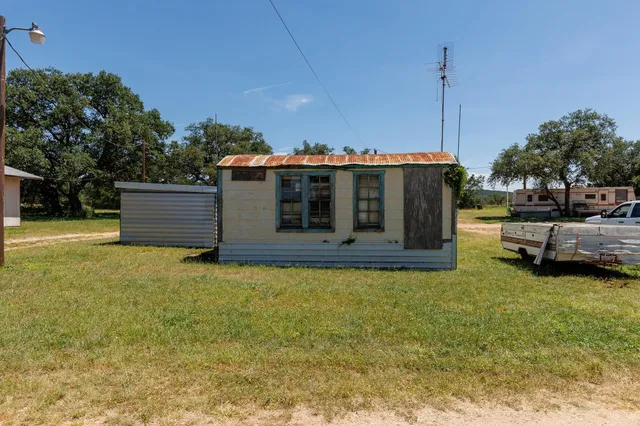 a view of a house with backyard and sitting area