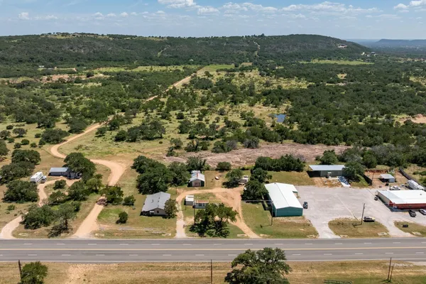 an aerial view of residential houses with outdoor space and trees