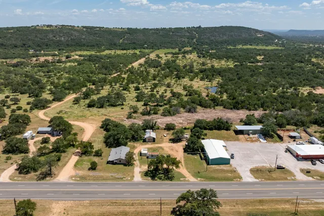 an aerial view of residential houses with outdoor space and trees