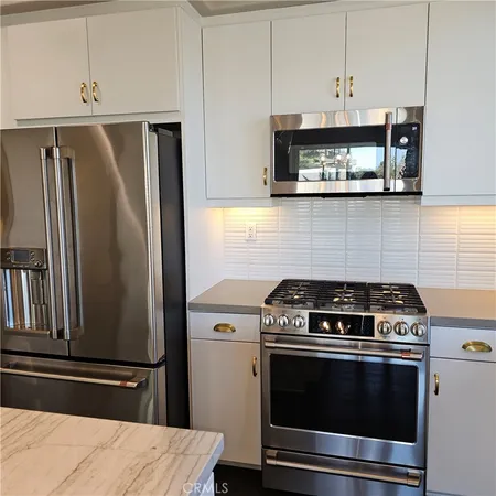 a kitchen with stainless steel appliances a sink stove and refrigerator