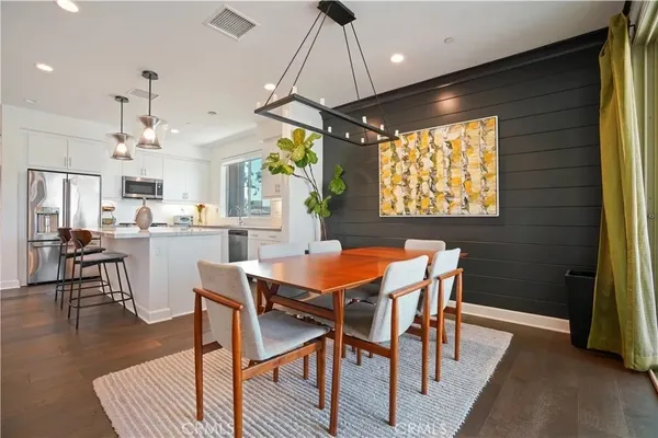 an open kitchen with a sink and dishwasher a stove top oven with wooden floor