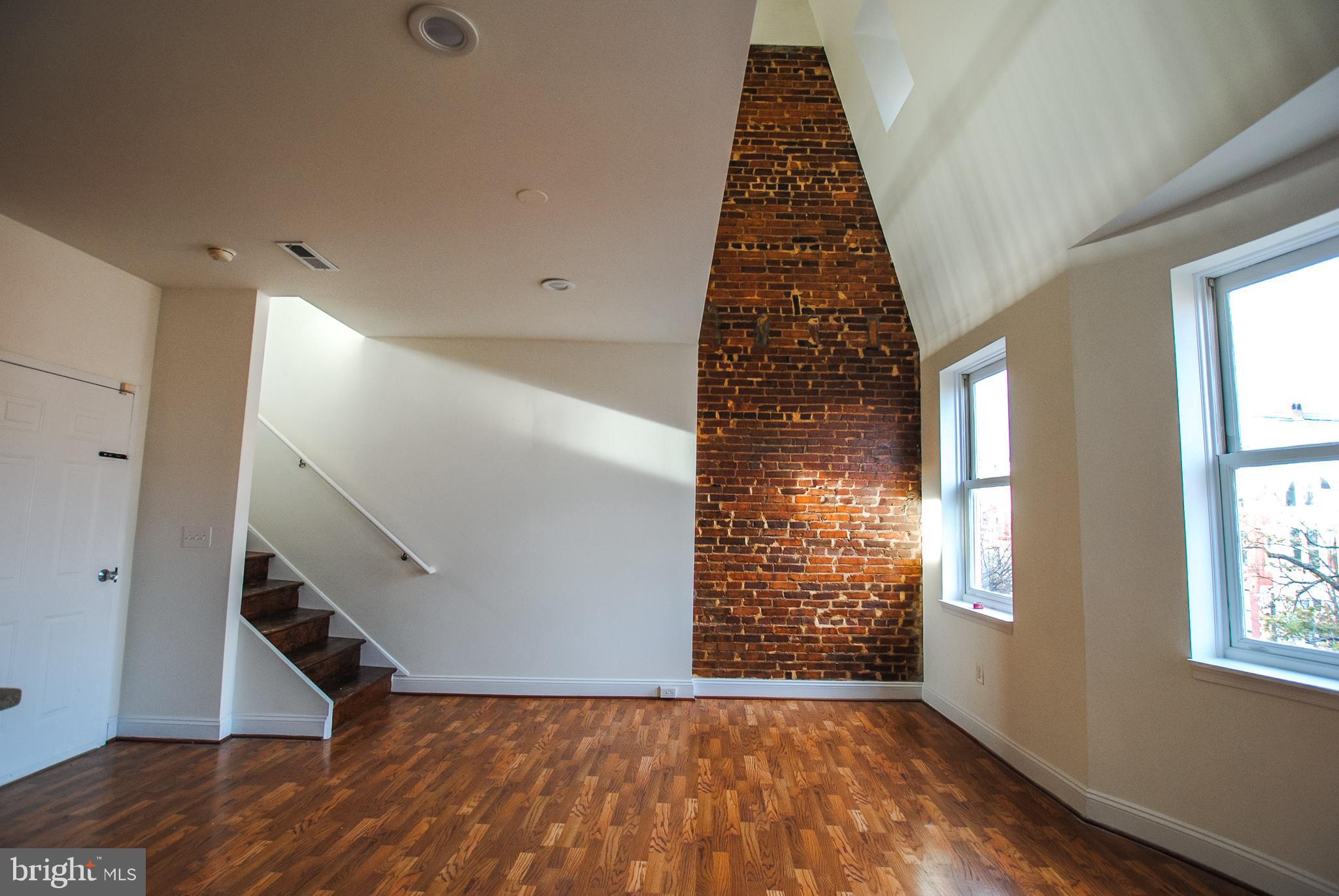 2210 Eutaw Place, Unit 3 Baltimore, MD 21217 - Photo 3 of 12 wooden floor in an empty room with a window