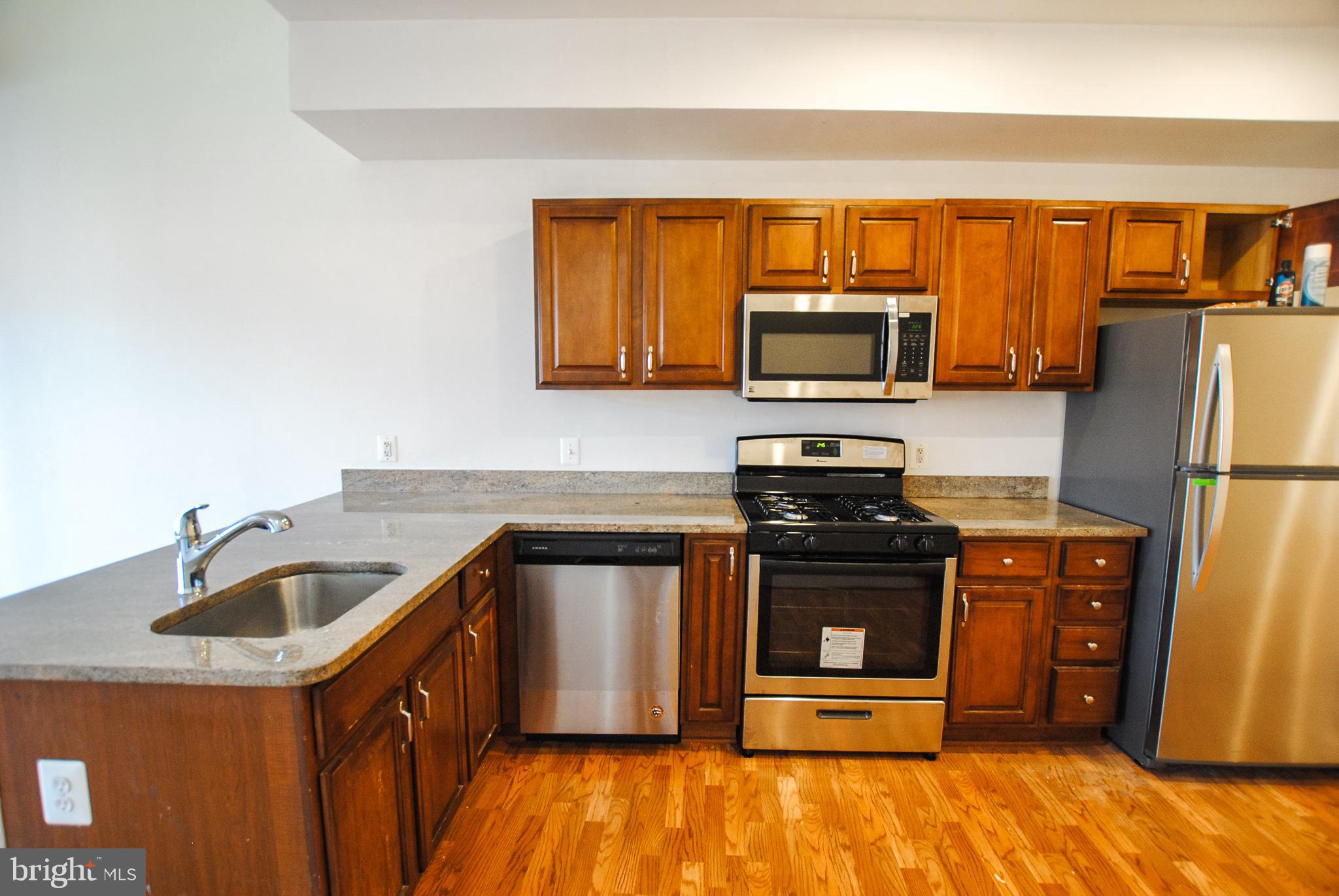 2210 Eutaw Place, Unit 3 Baltimore, MD 21217 - Photo 5 of 12 a kitchen with granite countertop a refrigerator stove and sink