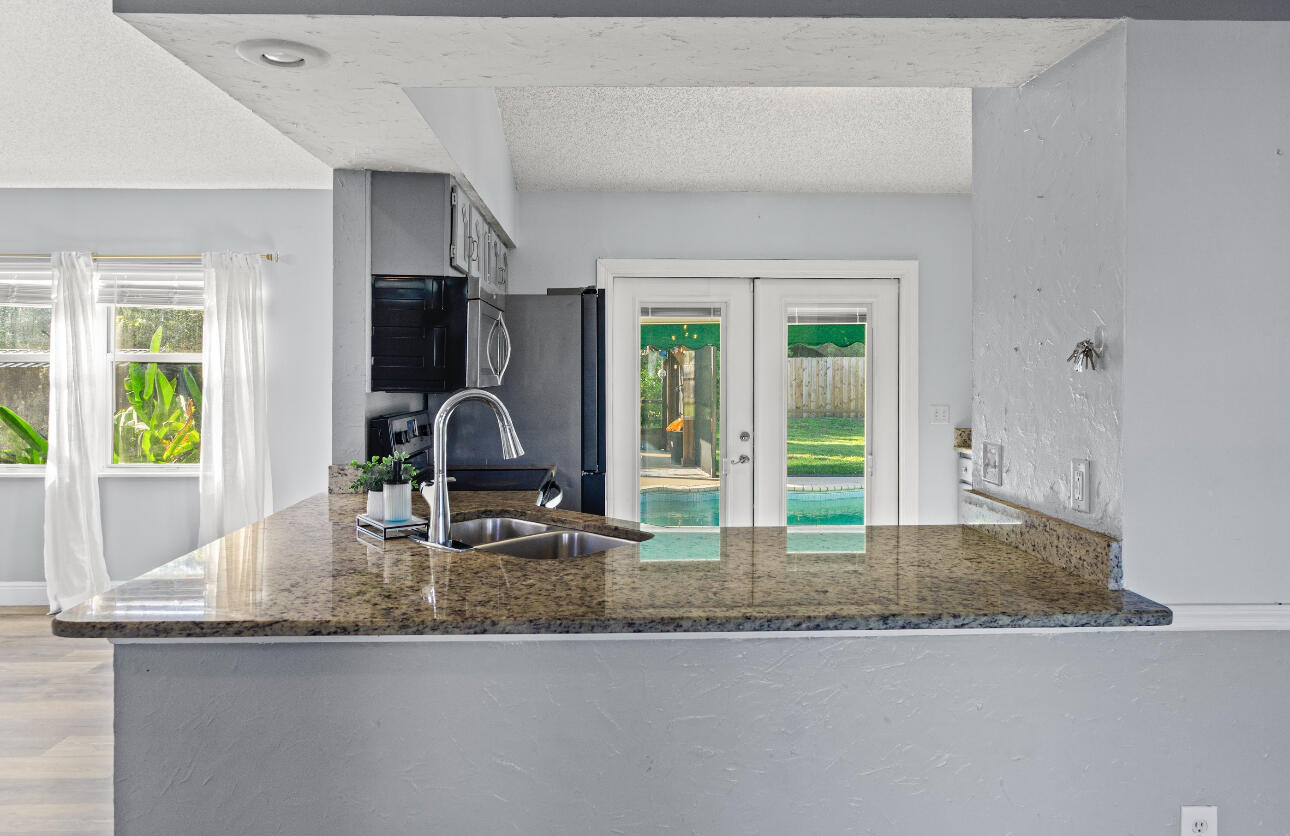 2230 Southeast Dill Lane Port St. Lucie, FL 34952 - Photo 5 of 15 a kitchen with granite countertop a sink and a window