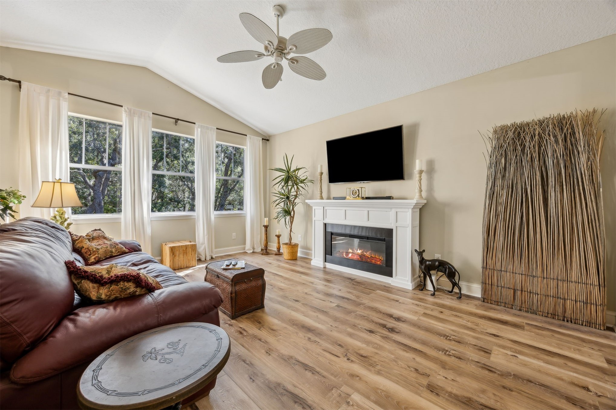 1839 Perimeter Park Road West, Unit 210 Fernandina Beach, FL 32034 - Photo 5 of 37 a living room with furniture a fireplace and a flat screen tv
