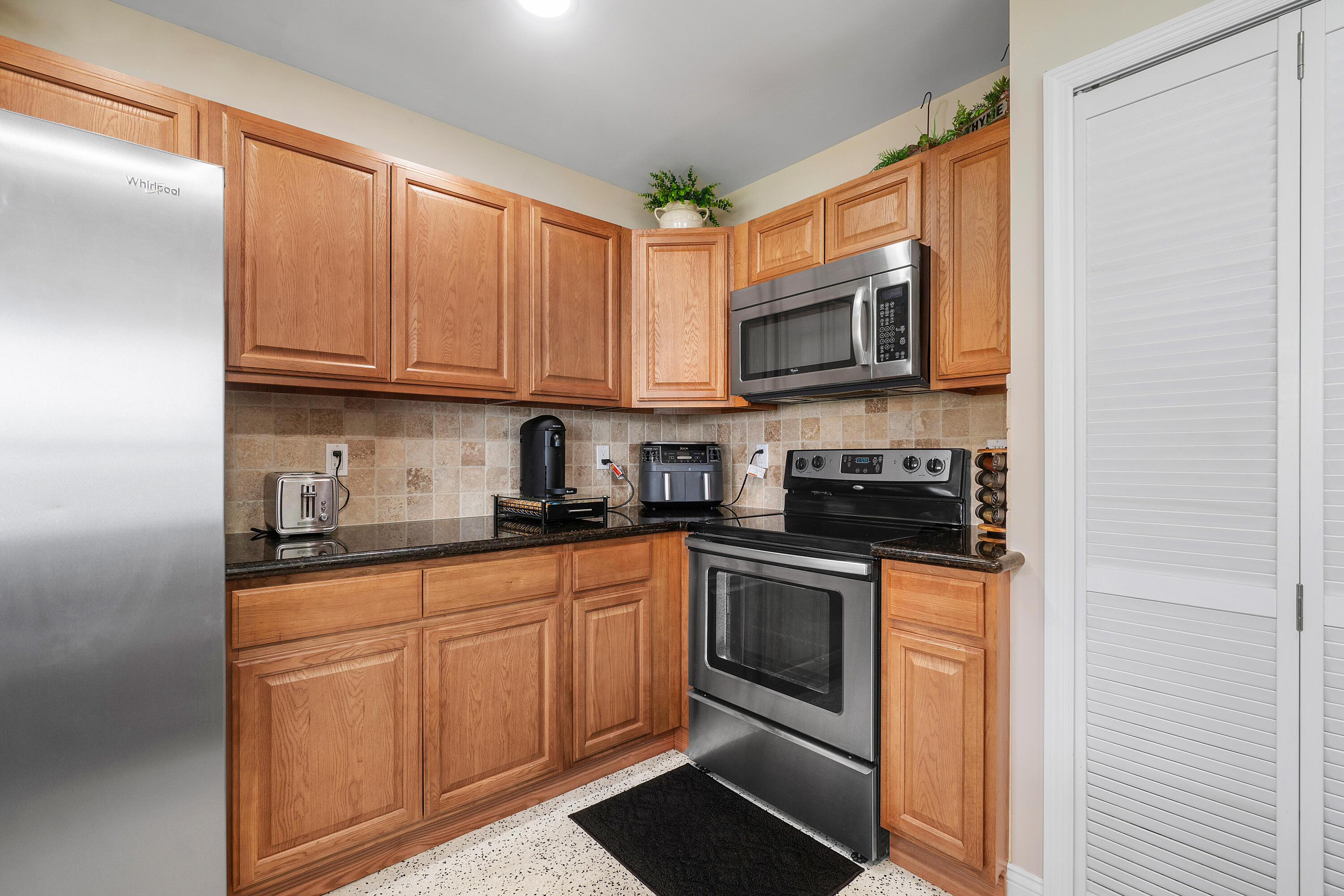 2757 Northeast 29th Avenue, Unit 2 Lighthouse Point, FL 33064 - Photo 13 of 29 a kitchen with stainless steel appliances granite countertop a stove sink microwave and cabinets