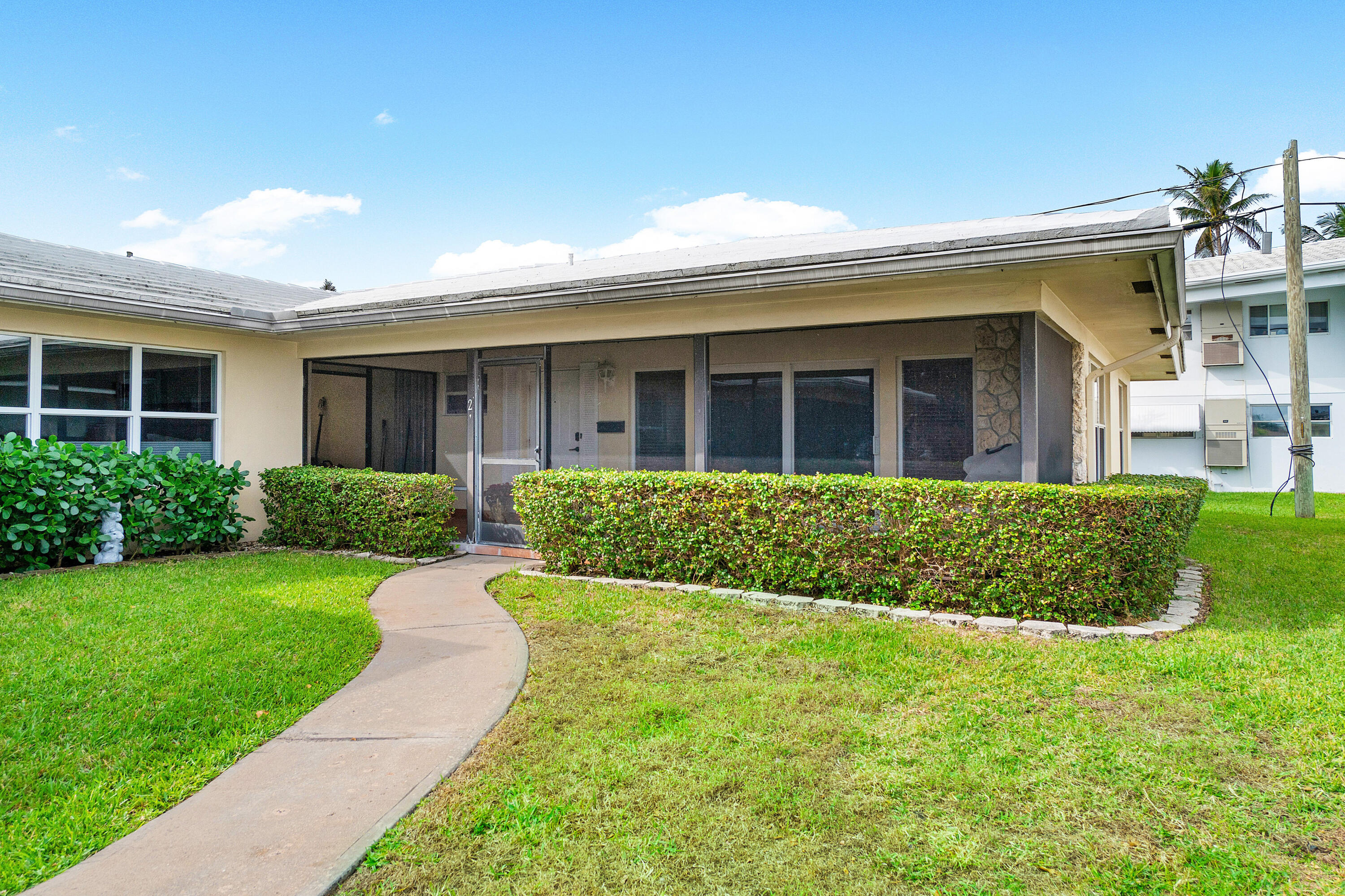 2757 Northeast 29th Avenue, Unit 2 Lighthouse Point, FL 33064 - Photo 2 of 29 a front view of a house with a yard