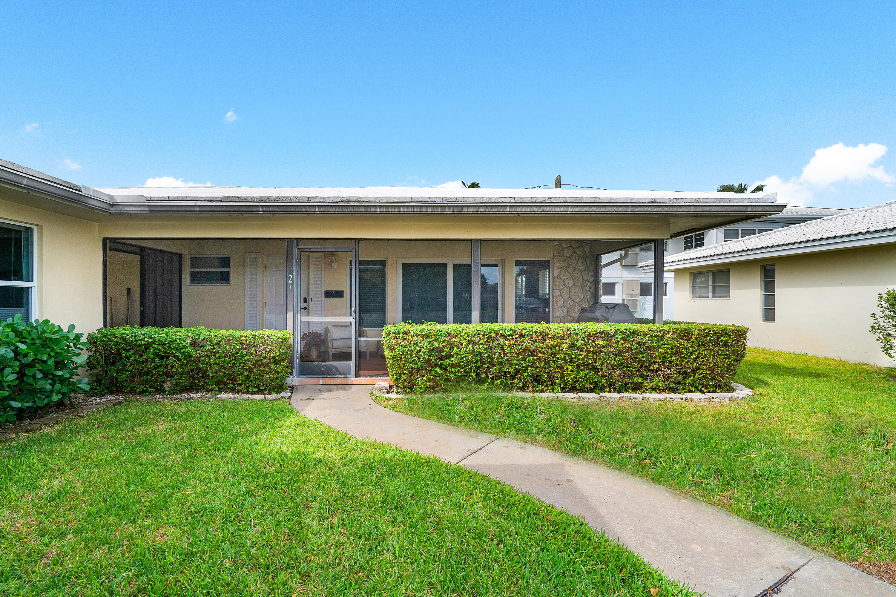 2757 Northeast 29th Avenue, Unit 2 Lighthouse Point, FL 33064 - Photo 3 of 29 a front view of house with yard and green space