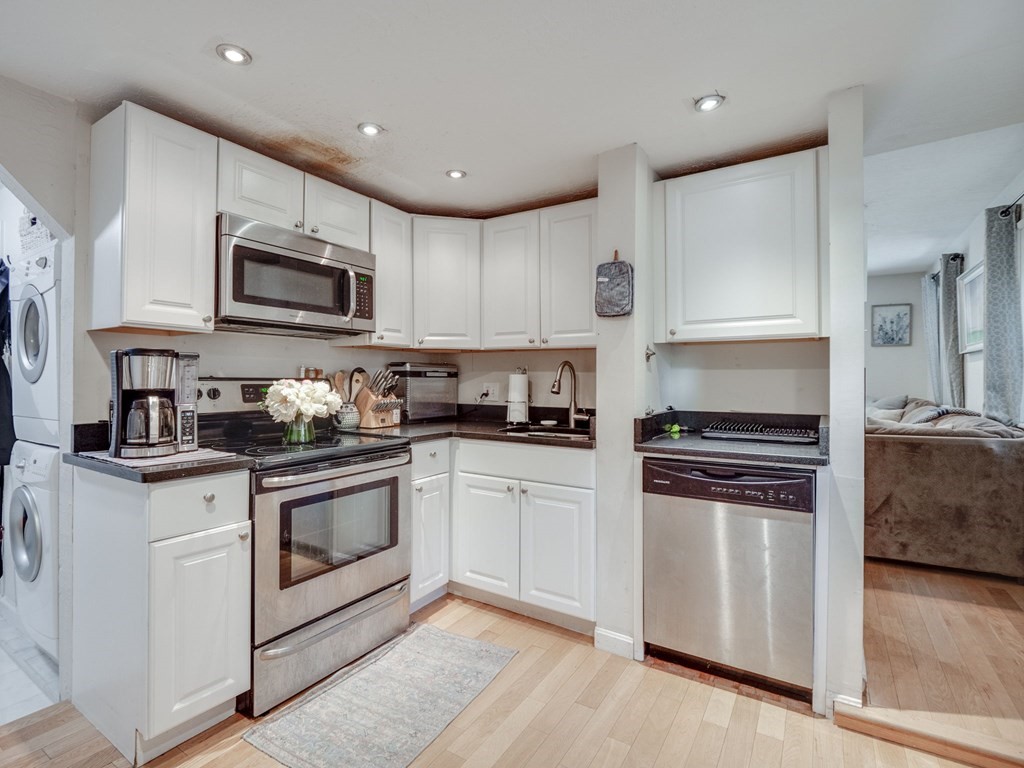 28 Mercer Street, Unit 2 Boston, MA 02127 - Photo 11 of 23 a kitchen with granite countertop white cabinets and stainless steel appliances