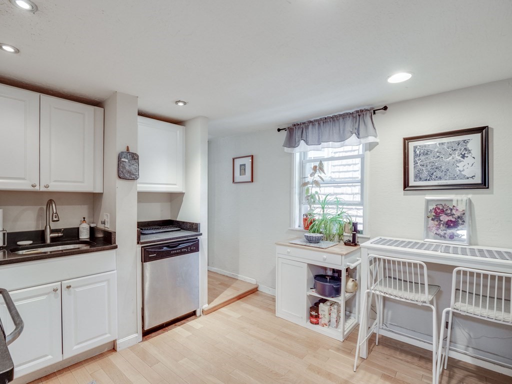 28 Mercer Street, Unit 2 Boston, MA 02127 - Photo 8 of 23 a kitchen with stainless steel appliances white cabinets and wooden floor