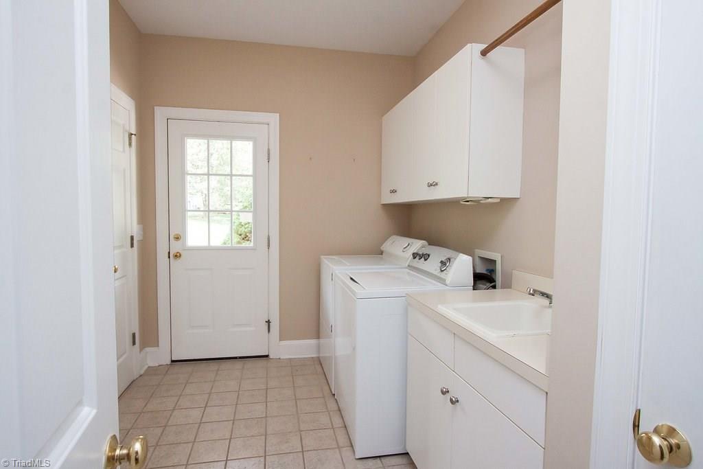 6104 Gwynedd Road Summerfield, NC 27358 - Photo 18 of 30 Main floor laundry with outside access is perfect for kids/pets/sports/gardeners. Utility sink too!