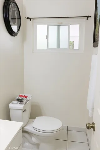 a white toilet sitting next to a bathroom sink and a vanity