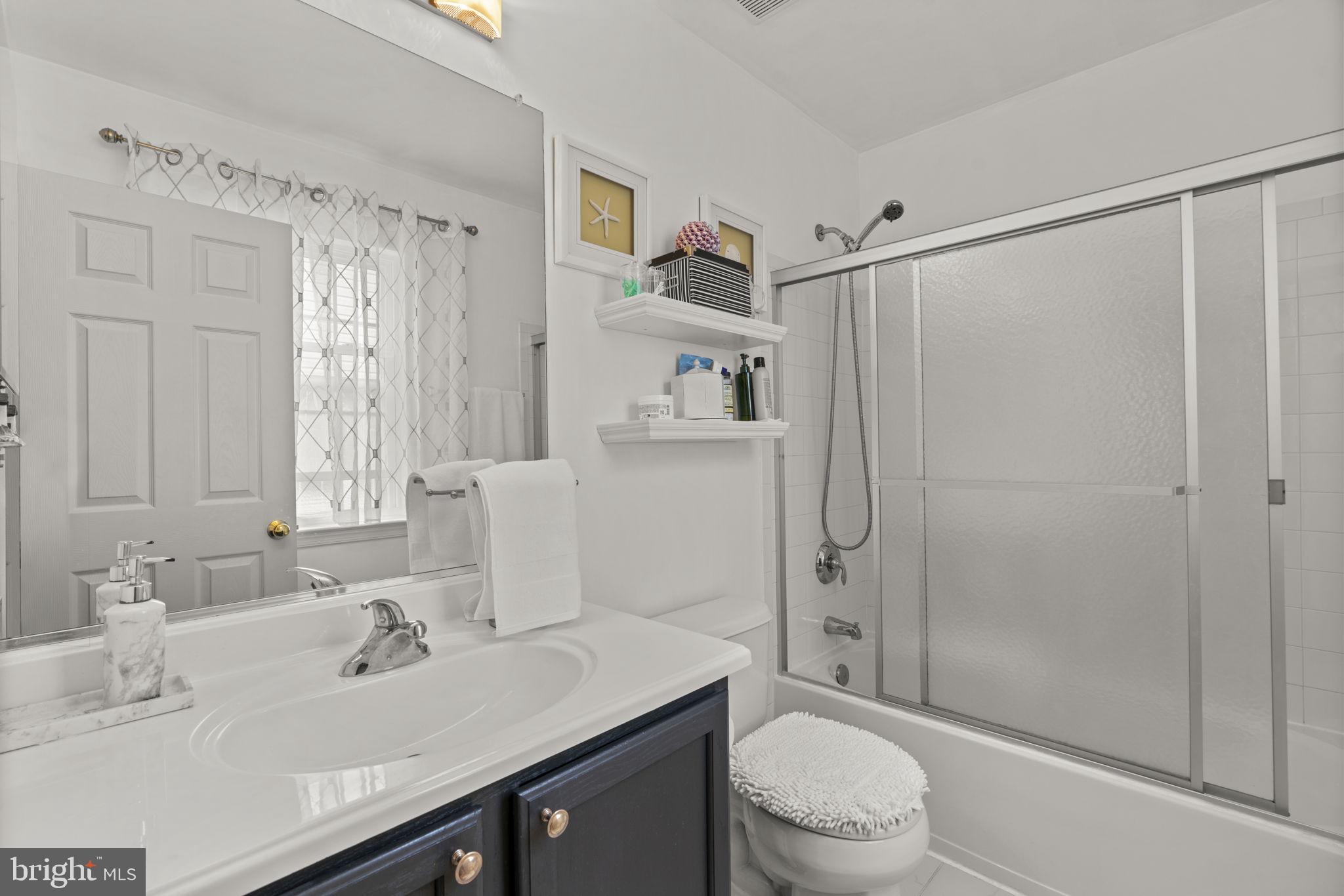 8057 Mayer Avenue Pasadena, MD 21122 - Photo 13 of 26 a bathroom with a sink a toilet and shower