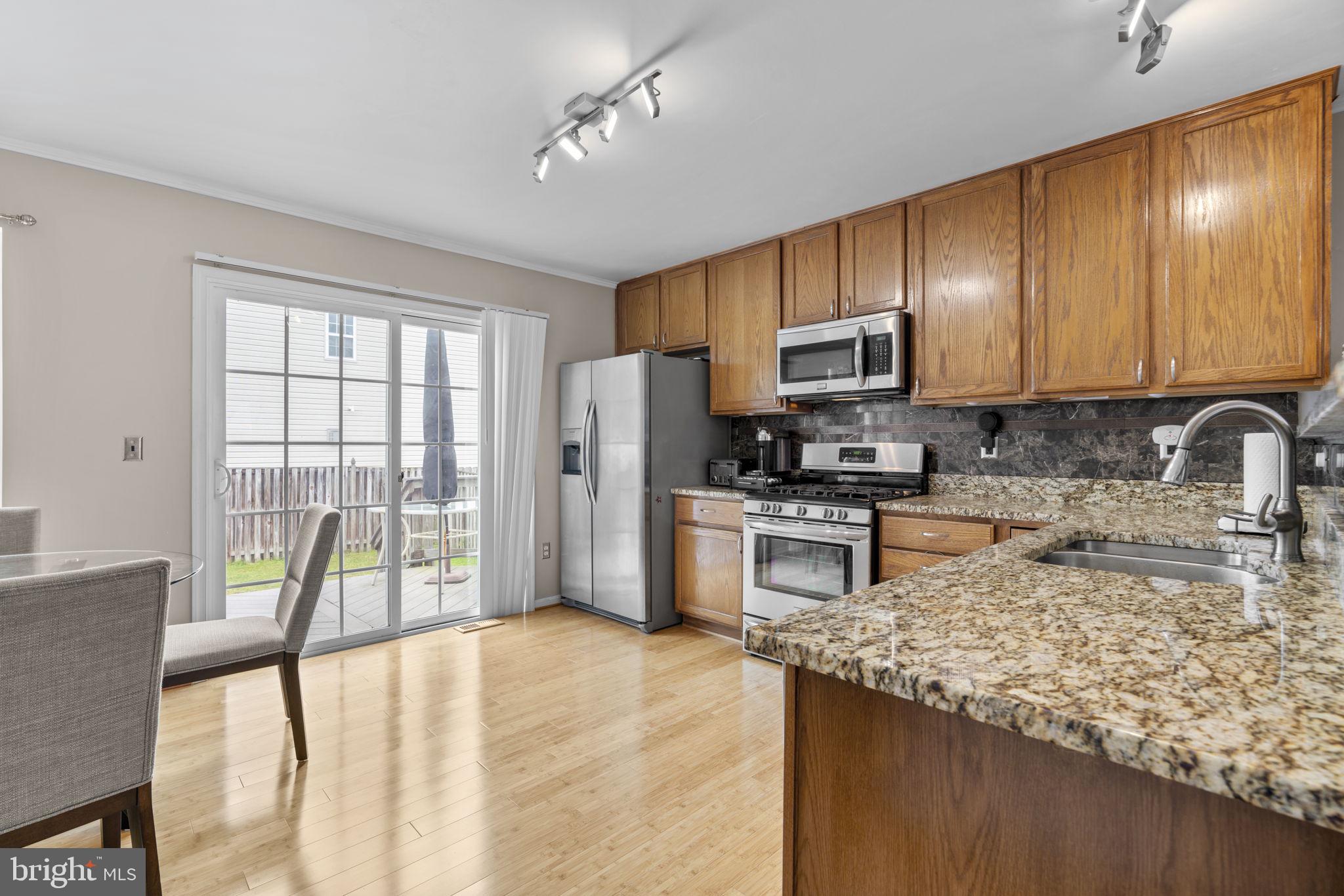 8057 Mayer Avenue Pasadena, MD 21122 - Photo 6 of 26 a kitchen with granite countertop wooden cabinets a stove top oven a sink and dishwasher