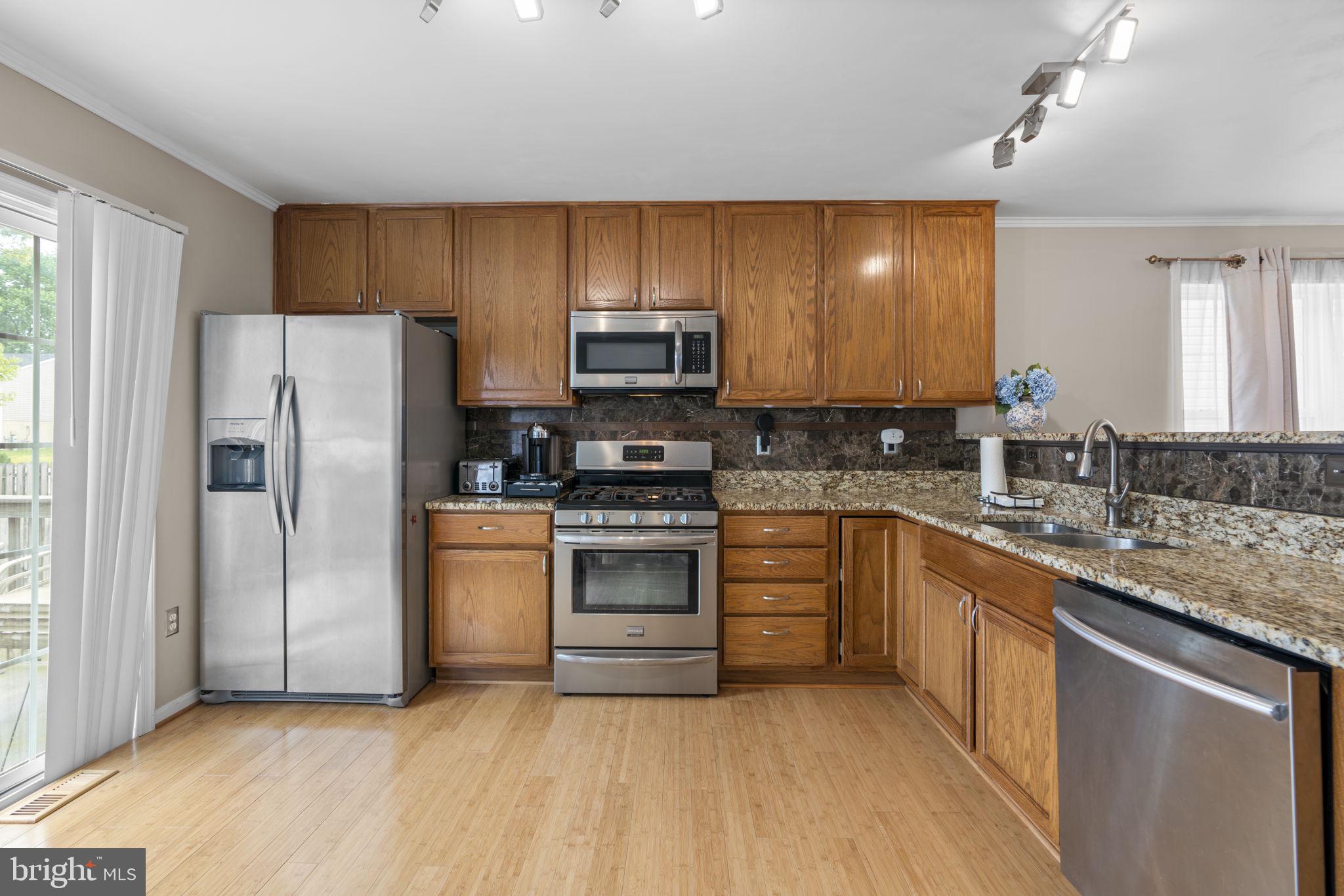 8057 Mayer Avenue Pasadena, MD 21122 - Photo 7 of 26 a kitchen with granite countertop a refrigerator stove top oven a sink and dishwasher