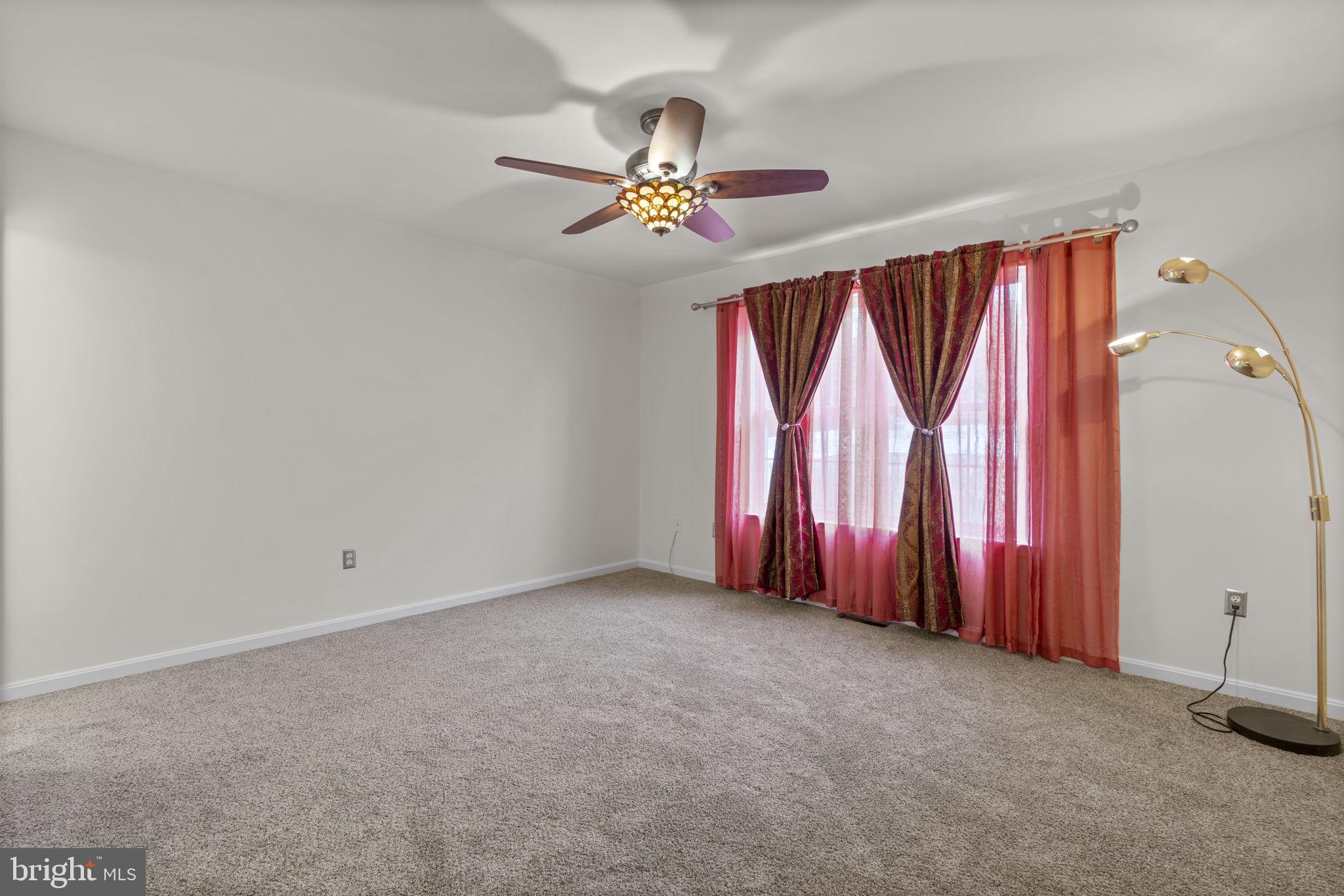 8057 Mayer Avenue Pasadena, MD 21122 - Photo 10 of 26 an empty room with windows and chandelier fan