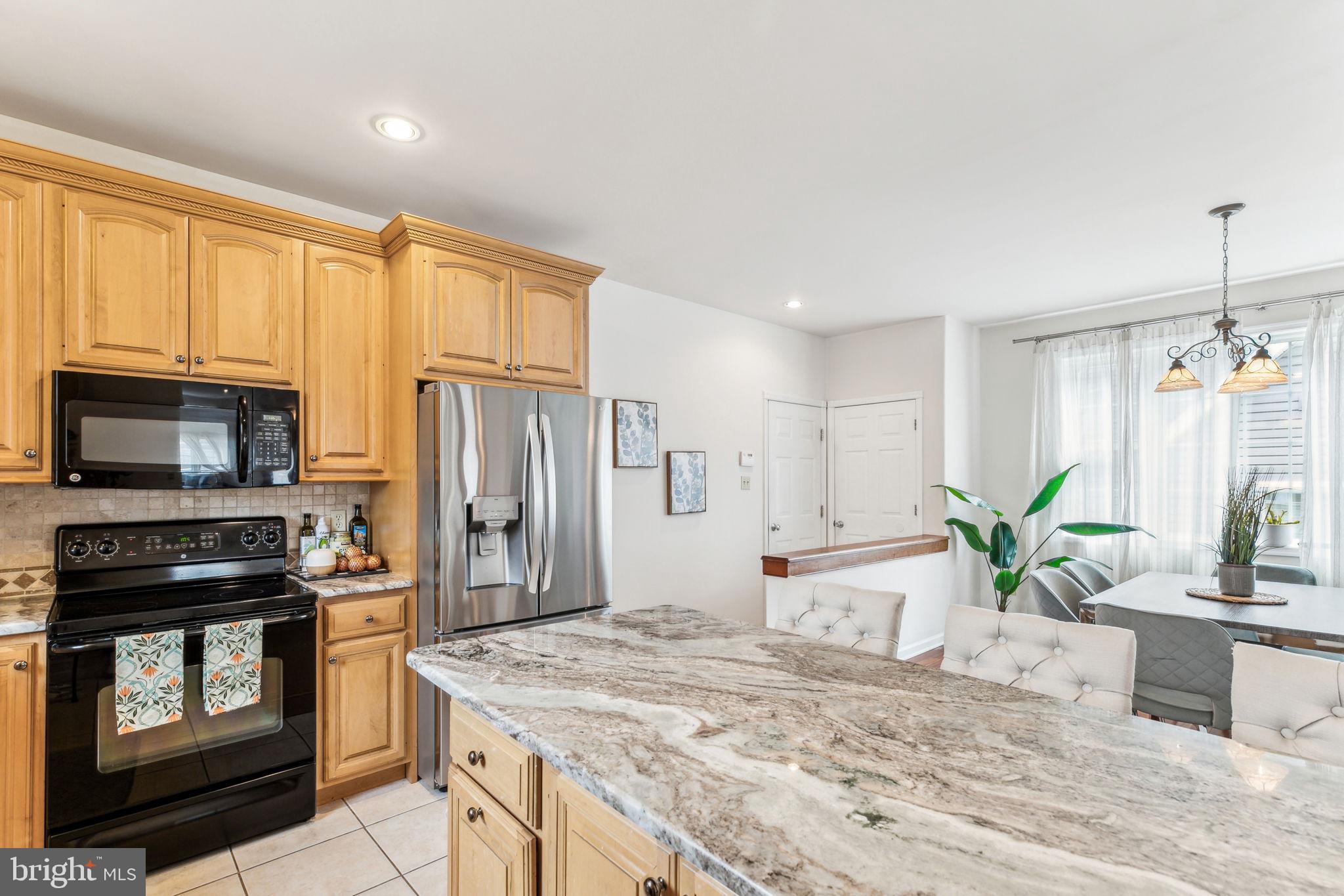316 Blakeley Road Wallingford, PA 19086 - Photo 12 of 34 a kitchen with kitchen island granite countertop a stove a sink and a refrigerator