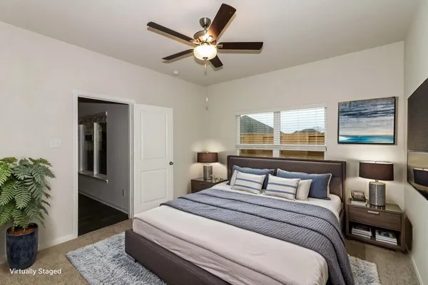 a bedroom with a large bed and a potted plant