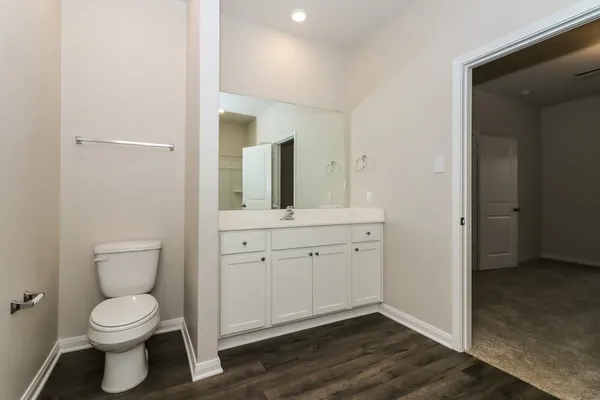 a bathroom with a toilet sink and mirror