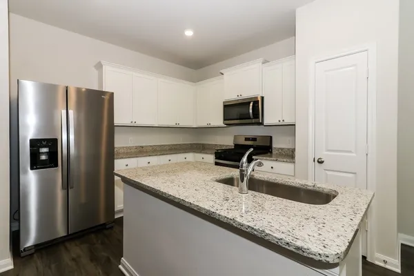 a kitchen with stainless steel appliances granite countertop a sink stove and refrigerator