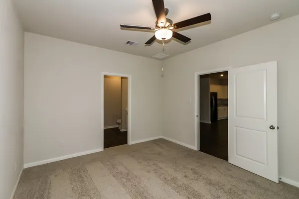 an empty room with closet and a ceiling fan