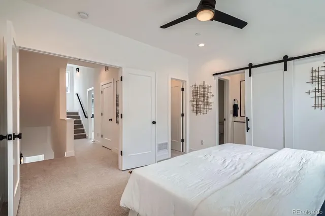 a spacious bedroom with a bed and a chandelier