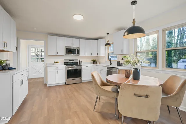 a kitchen with cabinets stainless steel appliances a sink and wooden floor