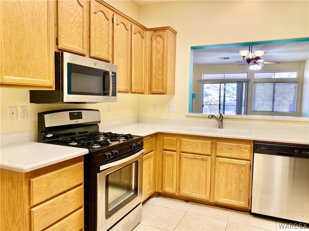 3171 Partridge Run Street Laughlin, NV 89029 - Photo 12 of 36 a kitchen with stainless steel appliances a stove a microwave and sink