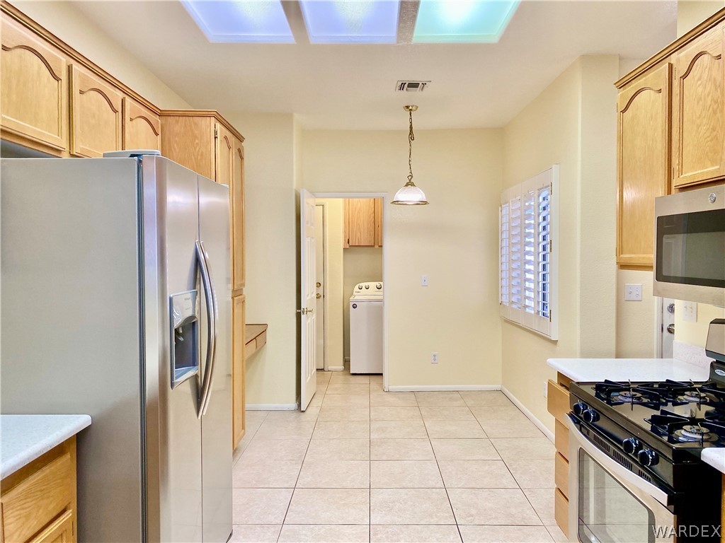 3171 Partridge Run Street Laughlin, NV 89029 - Photo 7 of 36 a kitchen with stainless steel appliances granite countertop a refrigerator and a stove top oven