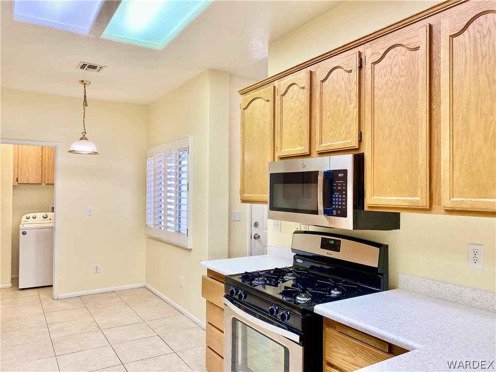 3171 Partridge Run Street Laughlin, NV 89029 - Photo 8 of 36 a kitchen with stainless steel appliances granite countertop a stove a sink and a microwave