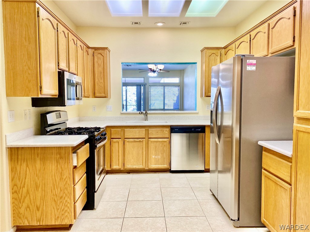 3171 Partridge Run Street Laughlin, NV 89029 - Photo 10 of 36 a kitchen with stainless steel appliances granite countertop a refrigerator and a stove top oven