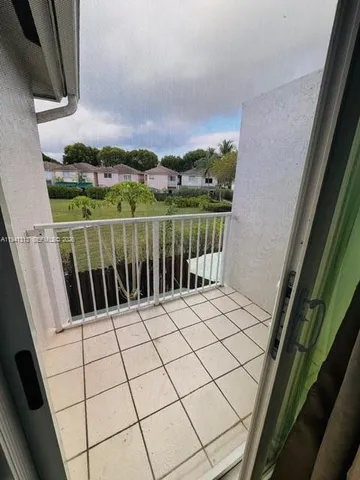 a spacious bedroom with a bed a flat screen tv and a window