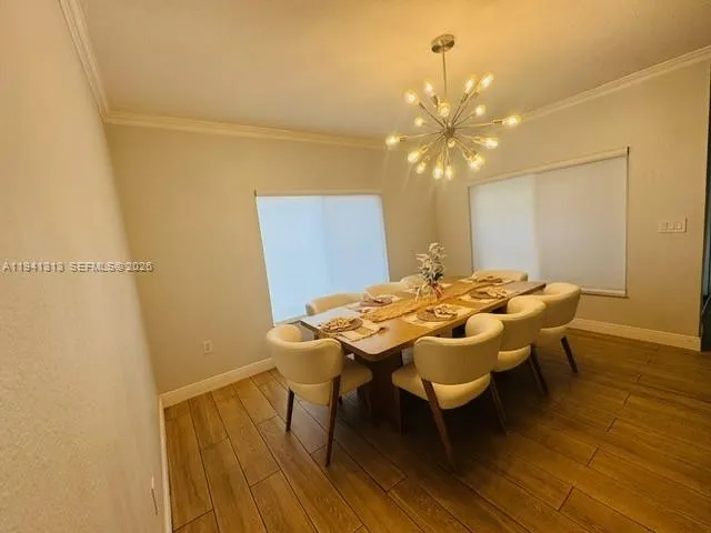 a kitchen with stainless steel appliances a refrigerator a stove a sink dishwasher and a dining table with wooden floor