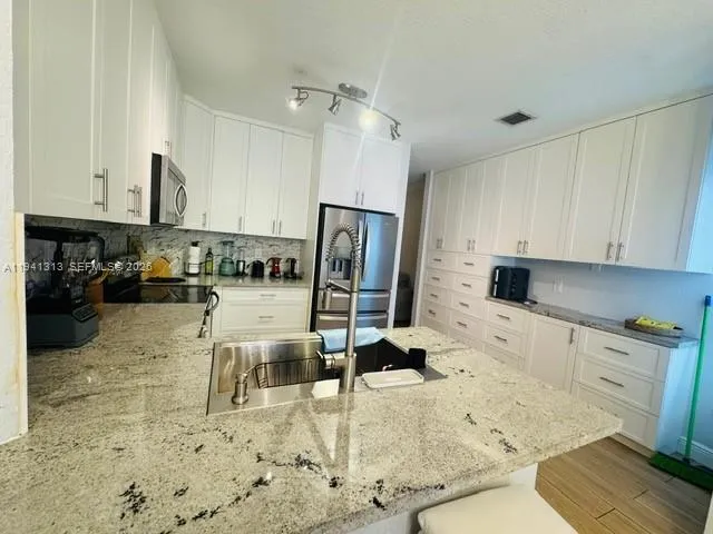 a kitchen with a sink appliances and cabinets