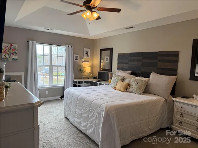 a bedroom with a large bed and wooden floor