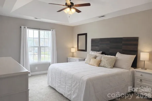 a bedroom with a large bed and a chandelier
