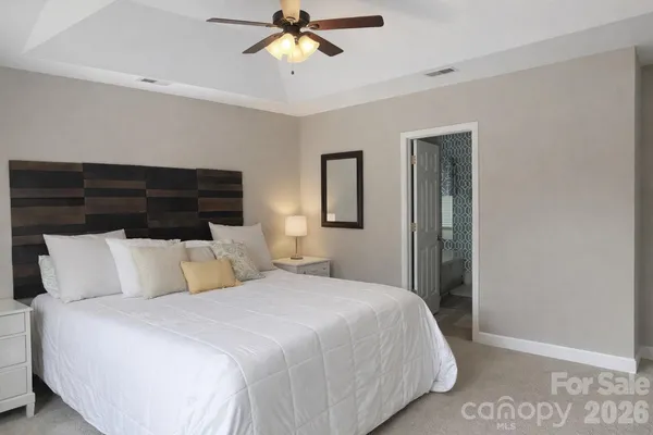 a bedroom with a large bed and a chandelier