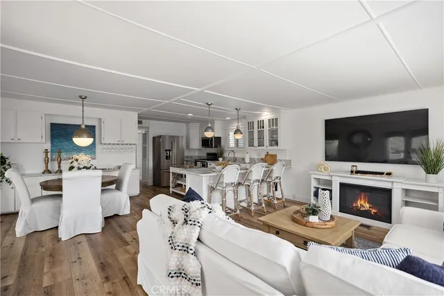 a living room with stainless steel appliances kitchen island granite countertop furniture wooden floor kitchen view and living room view