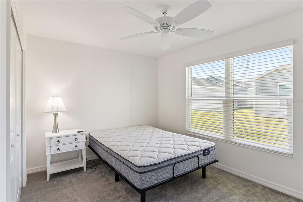6338 Flaxmayer Road The Villages, FL 32163 - Photo 13 of 19 a bedroom with a bed window and a chandelier