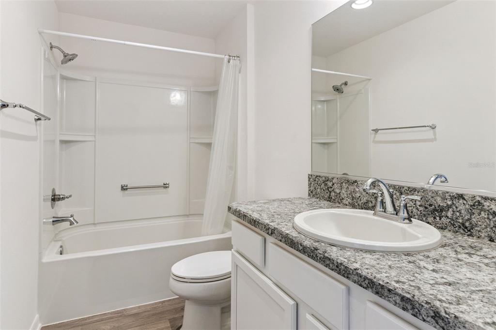 6338 Flaxmayer Road The Villages, FL 32163 - Photo 14 of 19 a bathroom with a granite countertop sink toilet and shower