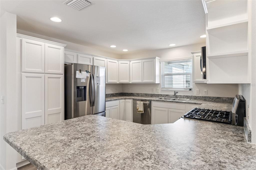 6338 Flaxmayer Road The Villages, FL 32163 - Photo 4 of 19 a kitchen with stainless steel appliances granite countertop a refrigerator stove sink and cabinets