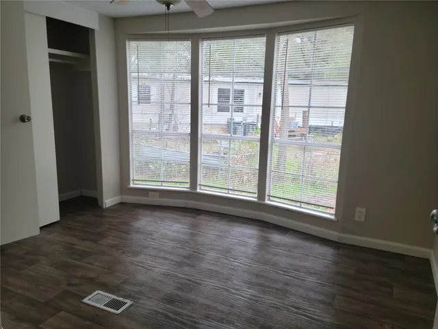 an empty room with wooden floor and windows