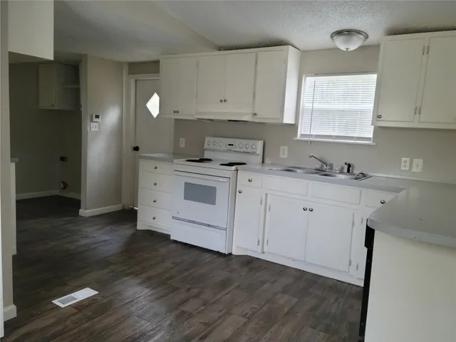 a kitchen with a sink cabinets and wooden floor