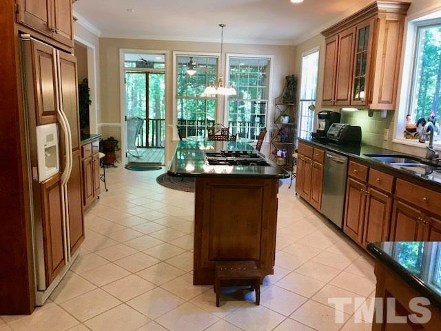 3425 Thomas Road Henderson, NC 27537 - Photo 6 of 25 a kitchen with stainless steel appliances granite countertop a refrigerator a sink dishwasher a stove a dining table and chairs with wooden floor