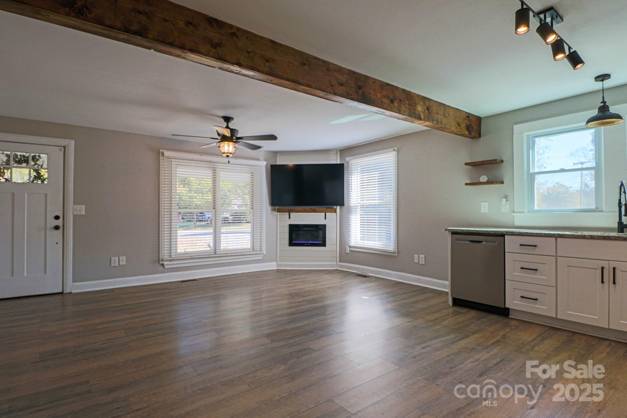 455 Stone Road Salisbury, NC 28146 - Photo 9 of 30 an empty room with wooden floor a ceiling fan and windows