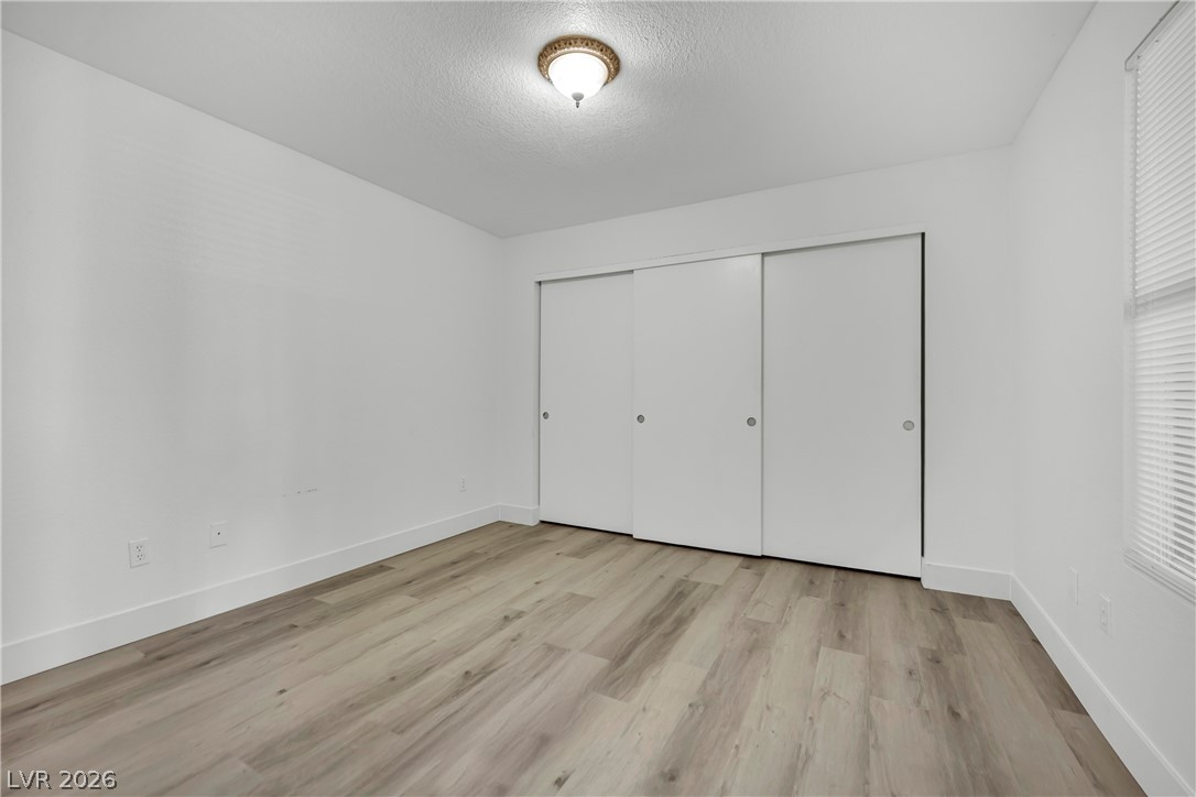 8101 West Flamingo Road, Unit 2030 Las Vegas, NV 89147 - Photo 15 of 27 Functional bedroom featuring ample closet space and durable wood flooring.