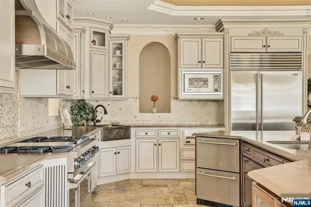 a kitchen with granite countertop a sink stainless steel appliances and cabinets
