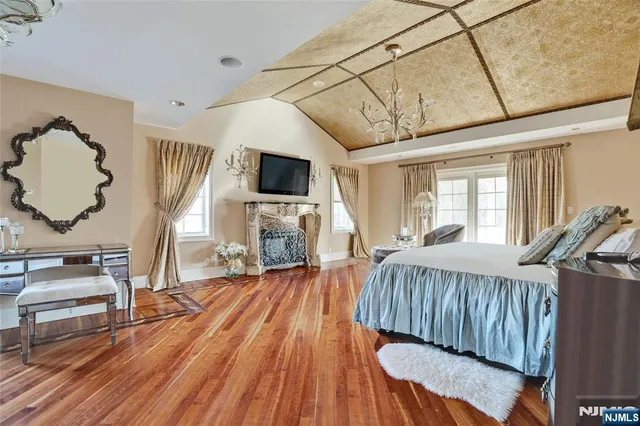 a view of a livingroom with furniture a flat screen tv and wooden floor